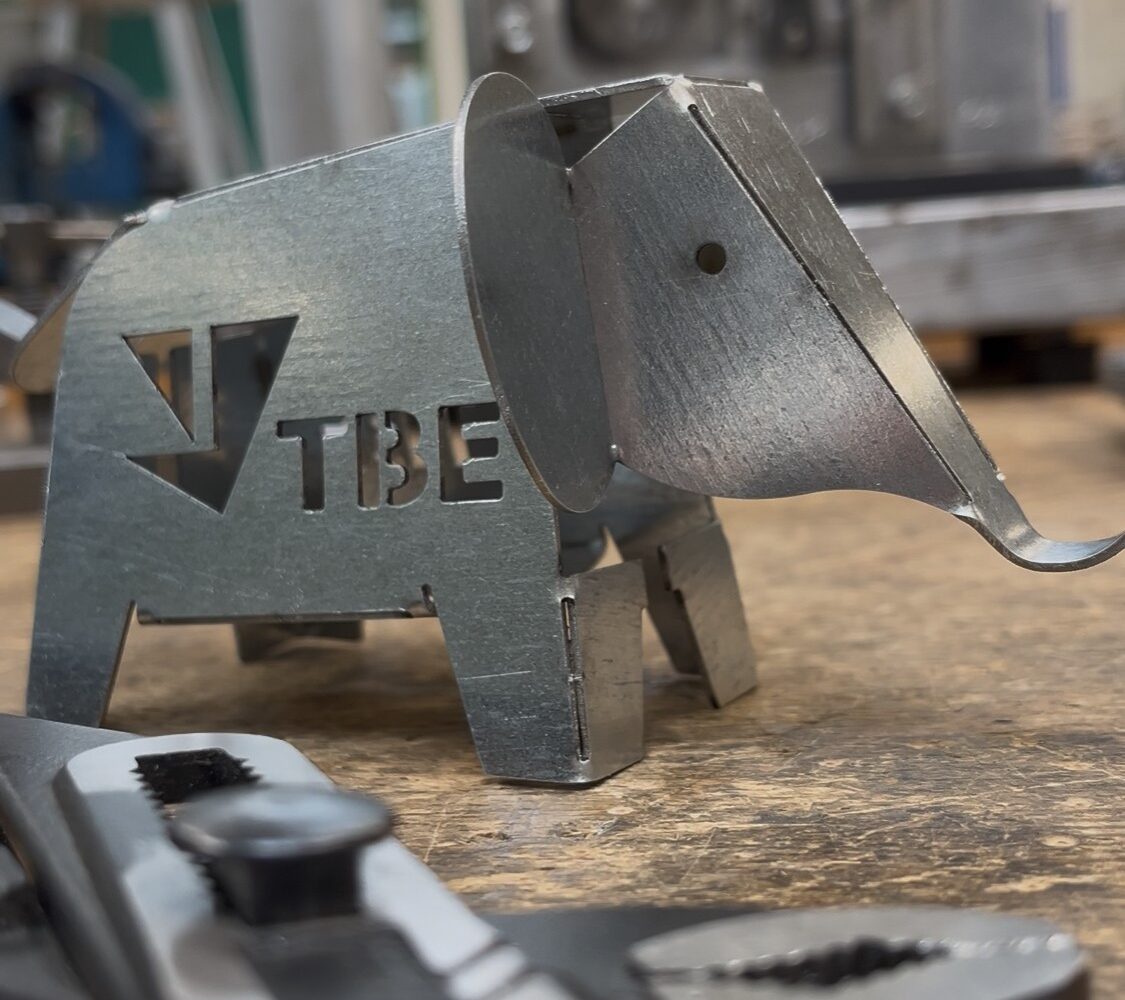 Metall-Elefant mit TBE-Logo auf Werkbank