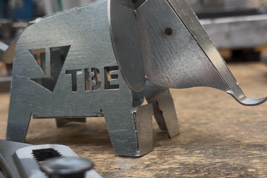 Metall-Elefant mit TBE-Logo auf Werkbank