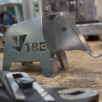 Metall-Elefant mit TBE-Logo auf Werkbank