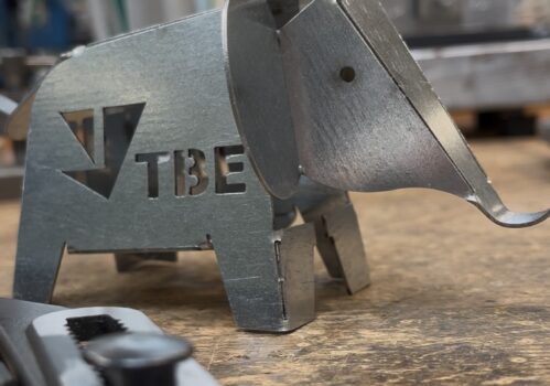 Metall-Elefant mit TBE-Logo auf Werkbank