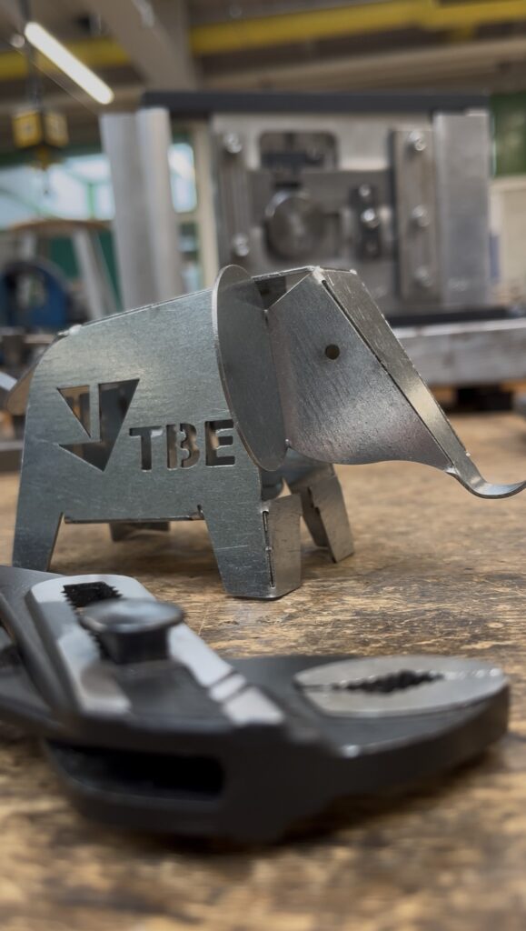 Metall-Elefant mit TBE-Logo auf Werkbank