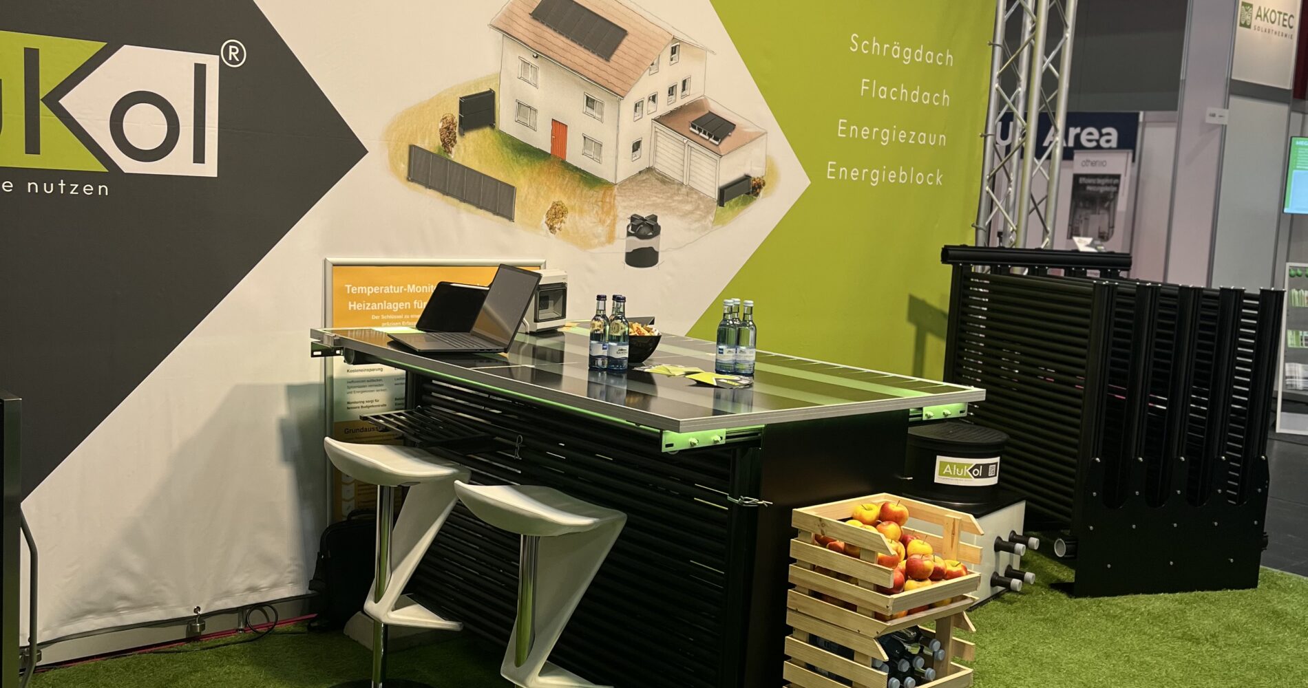 Messestand von AluKol® mit Tisch, Broschüren und dekorativen Elementen.
